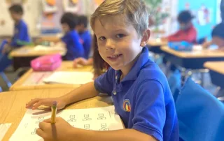 boy-in-school-uniform-holding-pencil