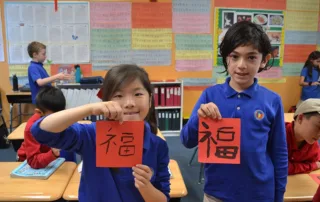 two-students-holding-up-work-for-display