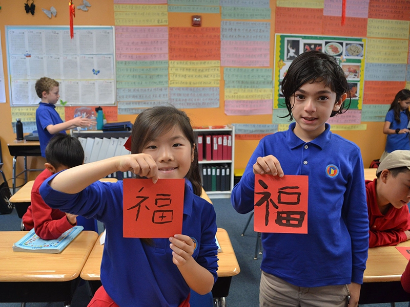 two-students-holding-up-work-for-display